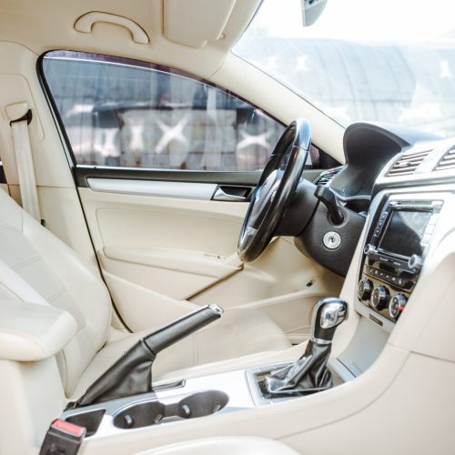 cropped image of steering wheel and leather seats new car on street